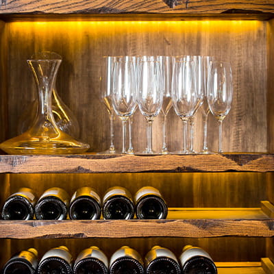 wijnflessen en wijnglazen in houten kast